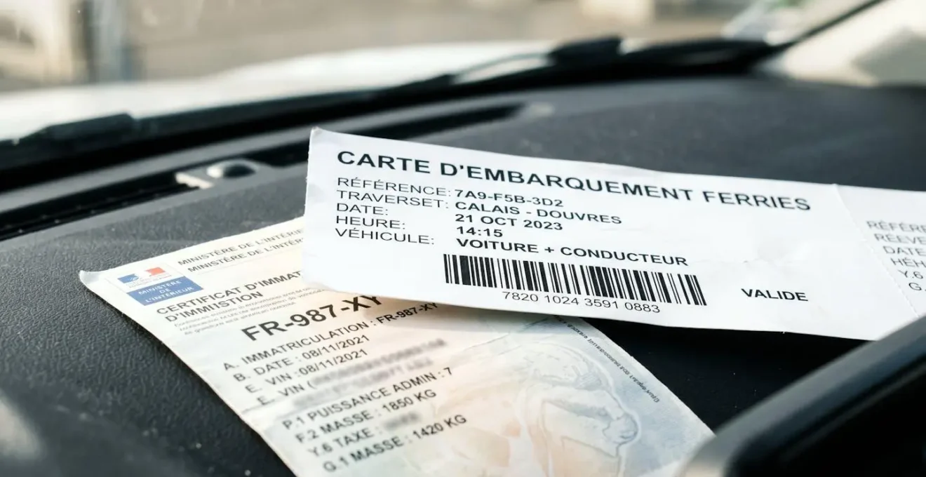 Gros plan en macro sur un billet de ferry avec code-barres et une carte grise posés sur le tableau de bord d'une voiture, avec une lumière naturelle latérale créant un bokeh flou en arrière-plan